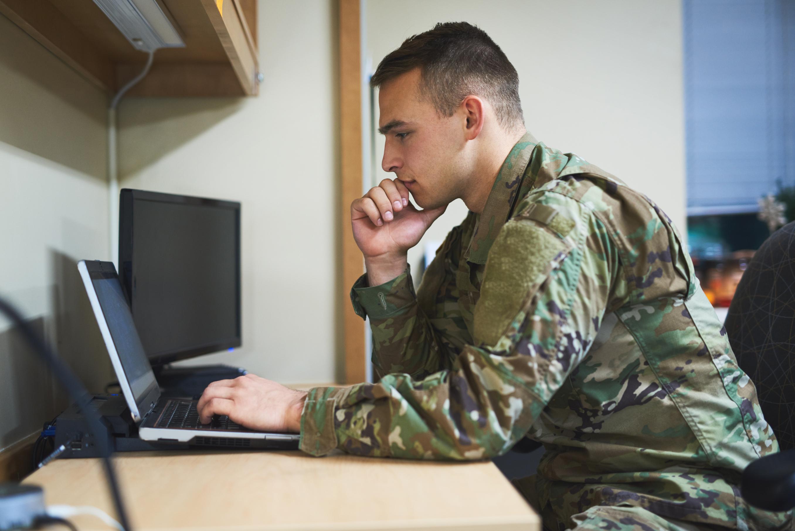 Military Member Using Laptop In Office