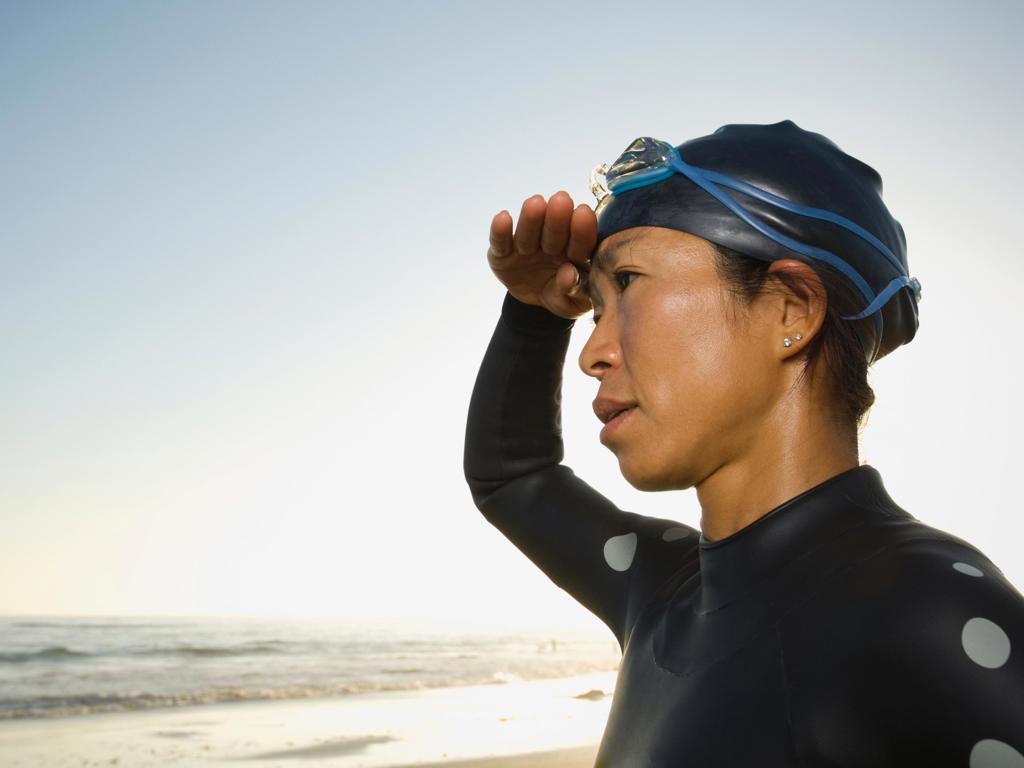 Woman In Wetsuit Looking Out Into Ocean