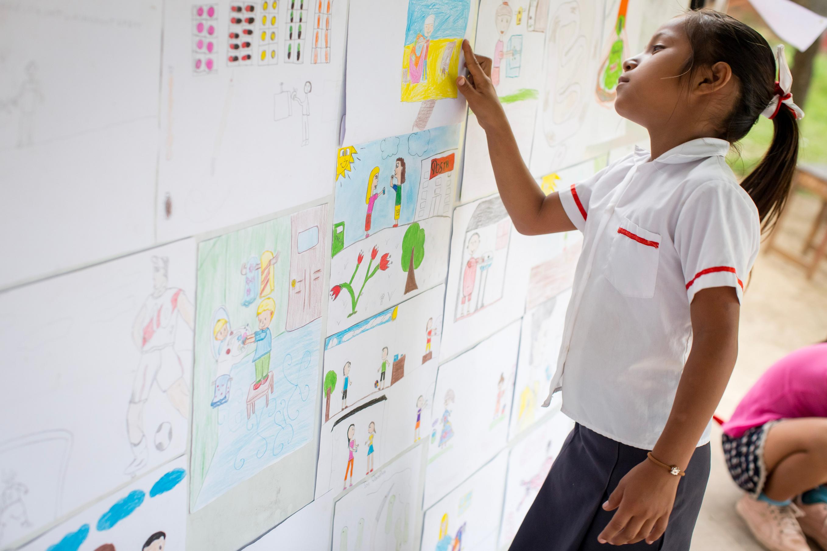 Student looking at artwork on a wall at school