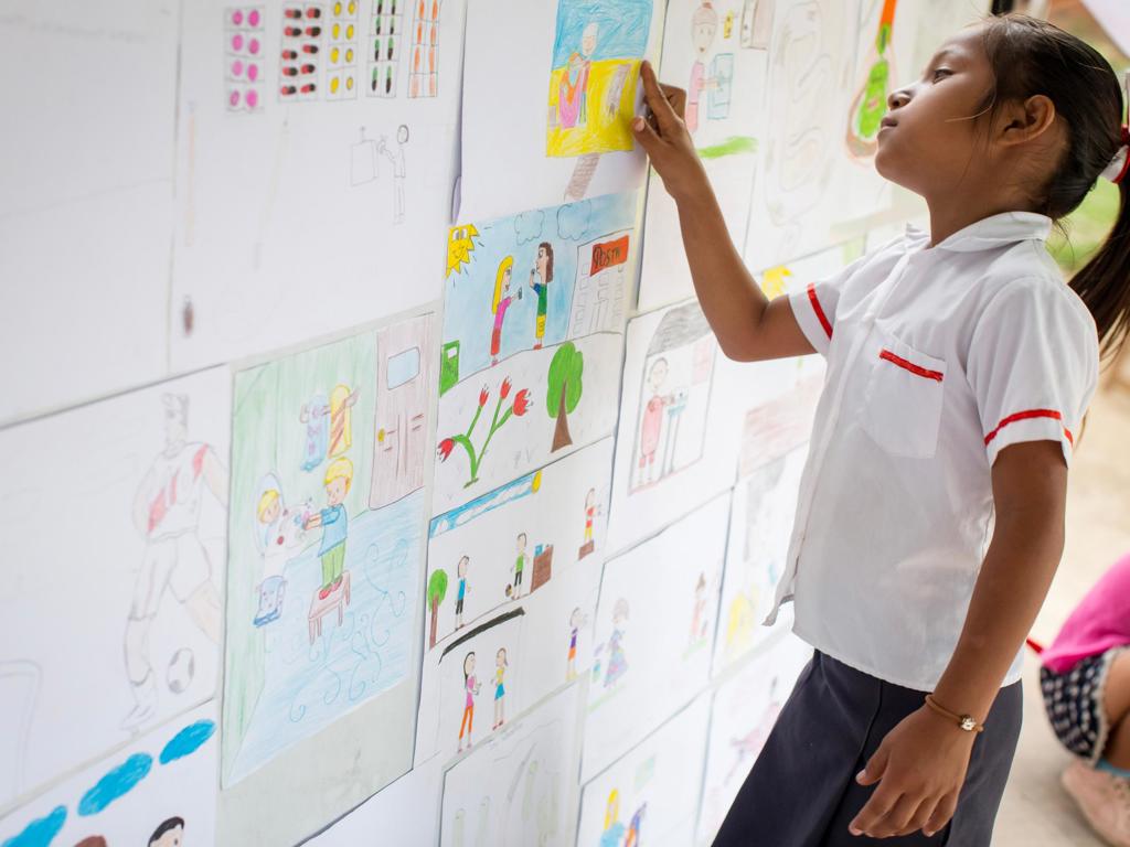 Student looking at artwork on a wall at school