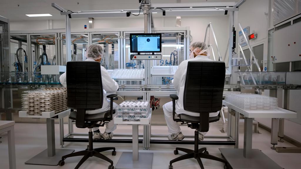 Two workers sitting on office chairs in a biomanufacturing facility