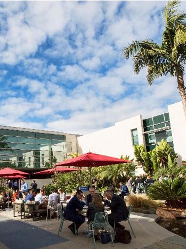Employees sitting under umbrellas outside at J&J Research Institute in La Jolla