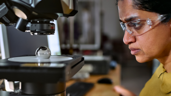 A close up of an engineer wearing safety glasses examining medtech technology