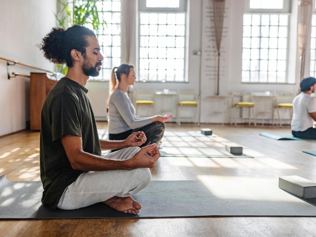 People sitting on yoga mats meditating