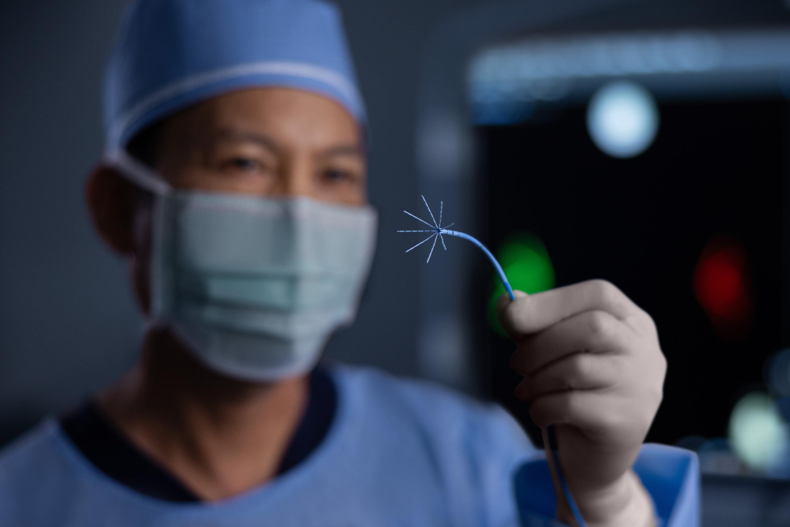 A physician holding a J&J MedTech device