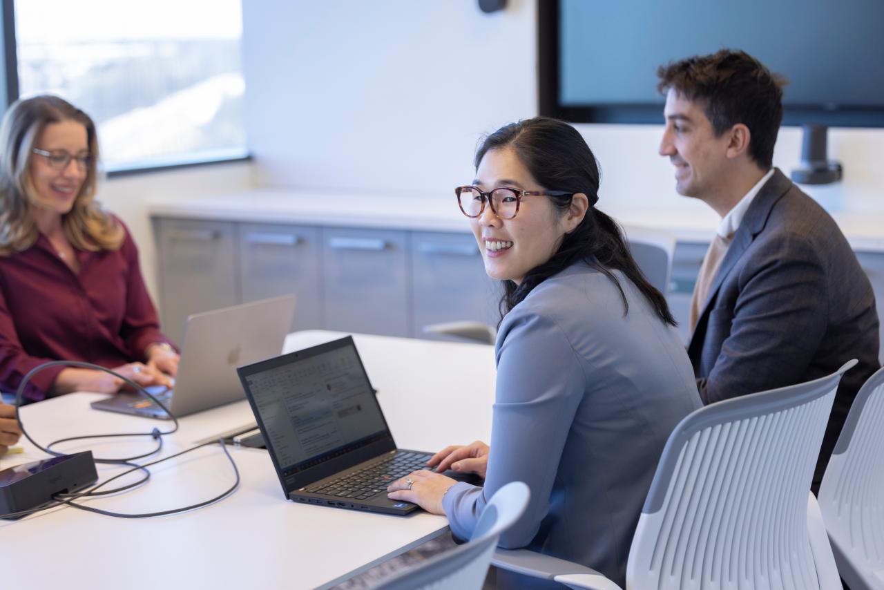 A group of people sit around a table in an office