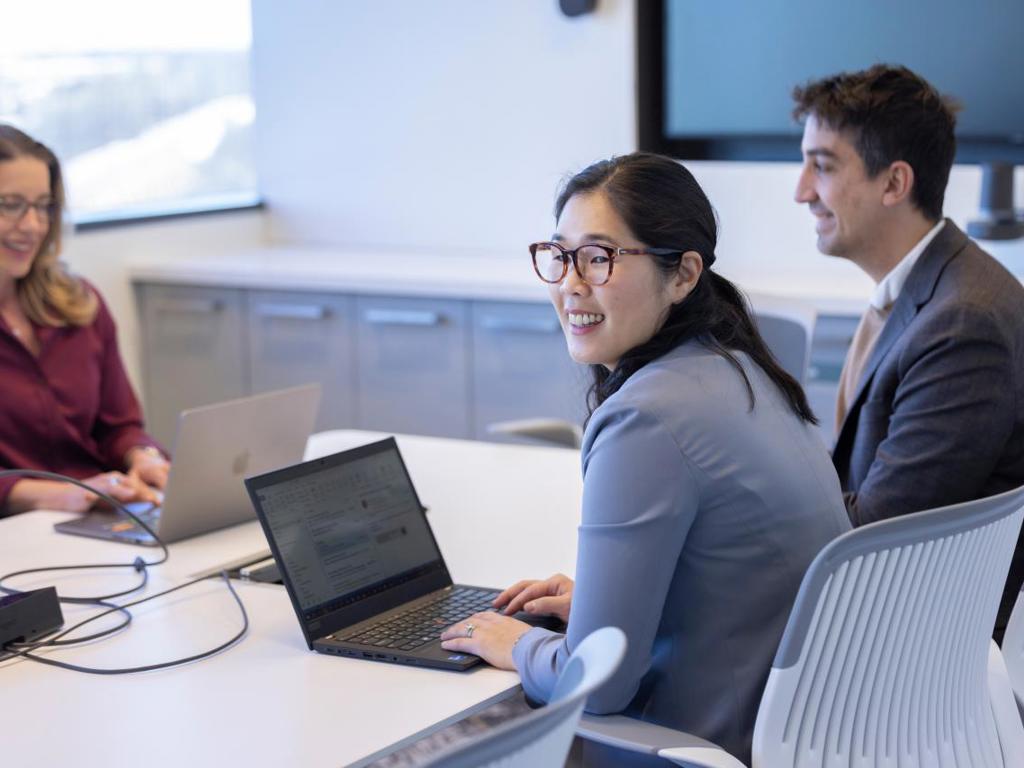 A group of people sit around a table in an office