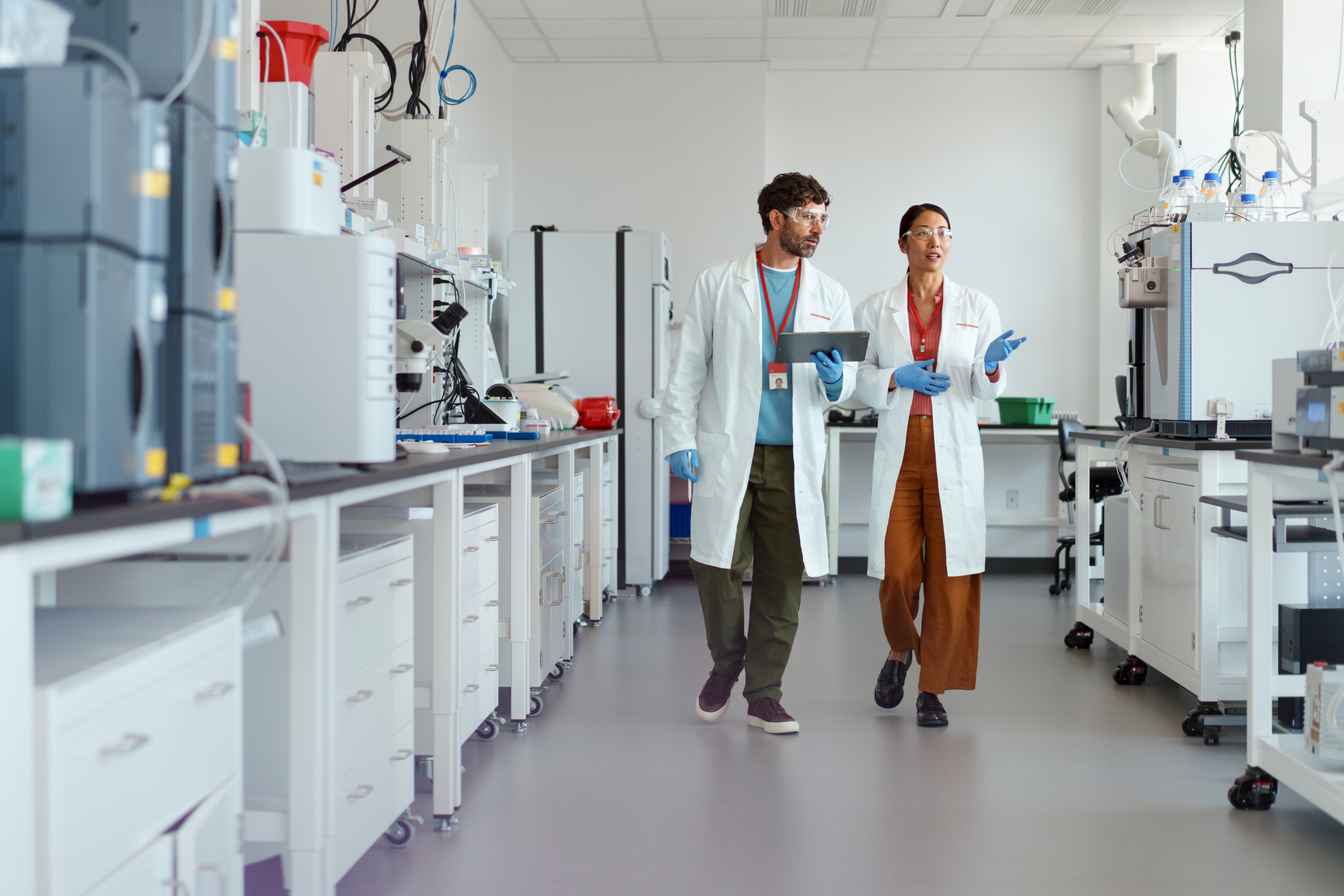 Scientists in discussion and walking through laboratory.