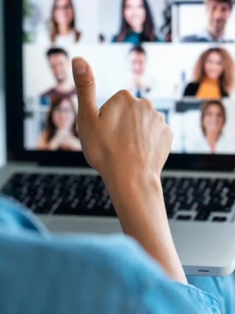 A person gives the thumbs-up at the end of a virtual meeting