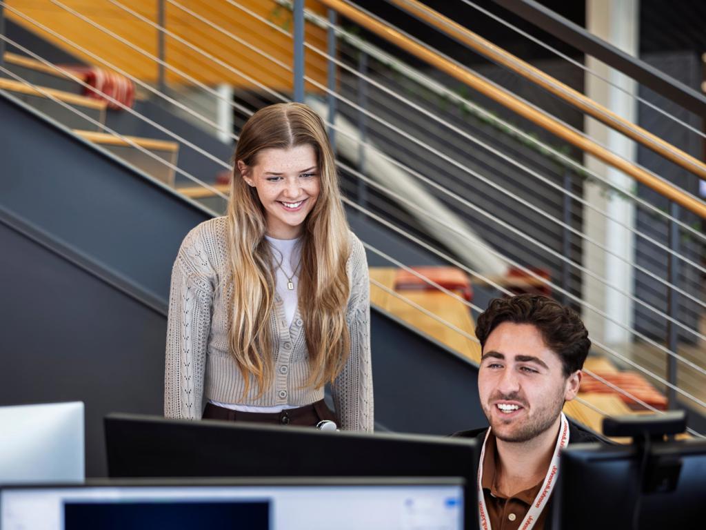 Two coworkers collaborate in an office