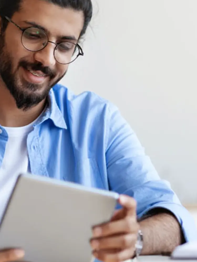 A man looks at a tablet and smiles