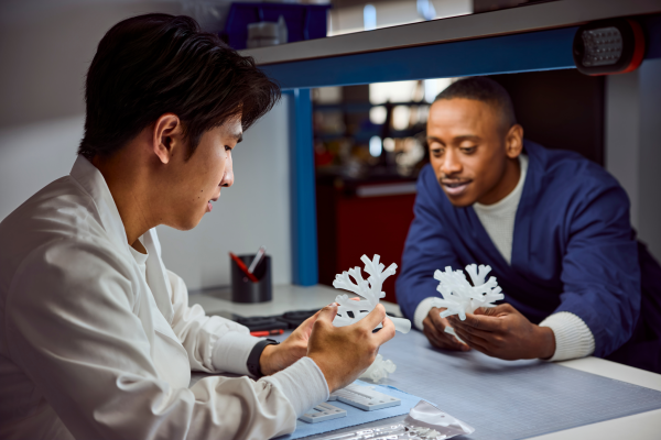 Two people examining 3D-printed models of airways in the lung.