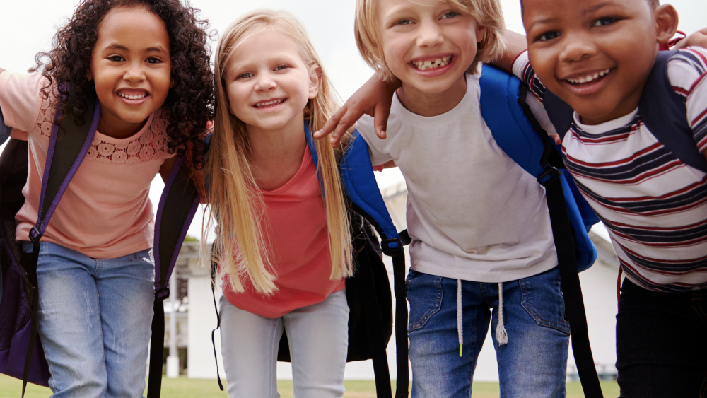 Group of young children hugging outside