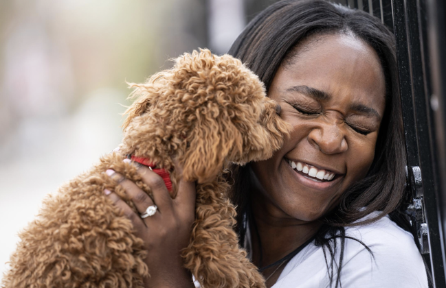 A happy pet owner embraces her beloved dog