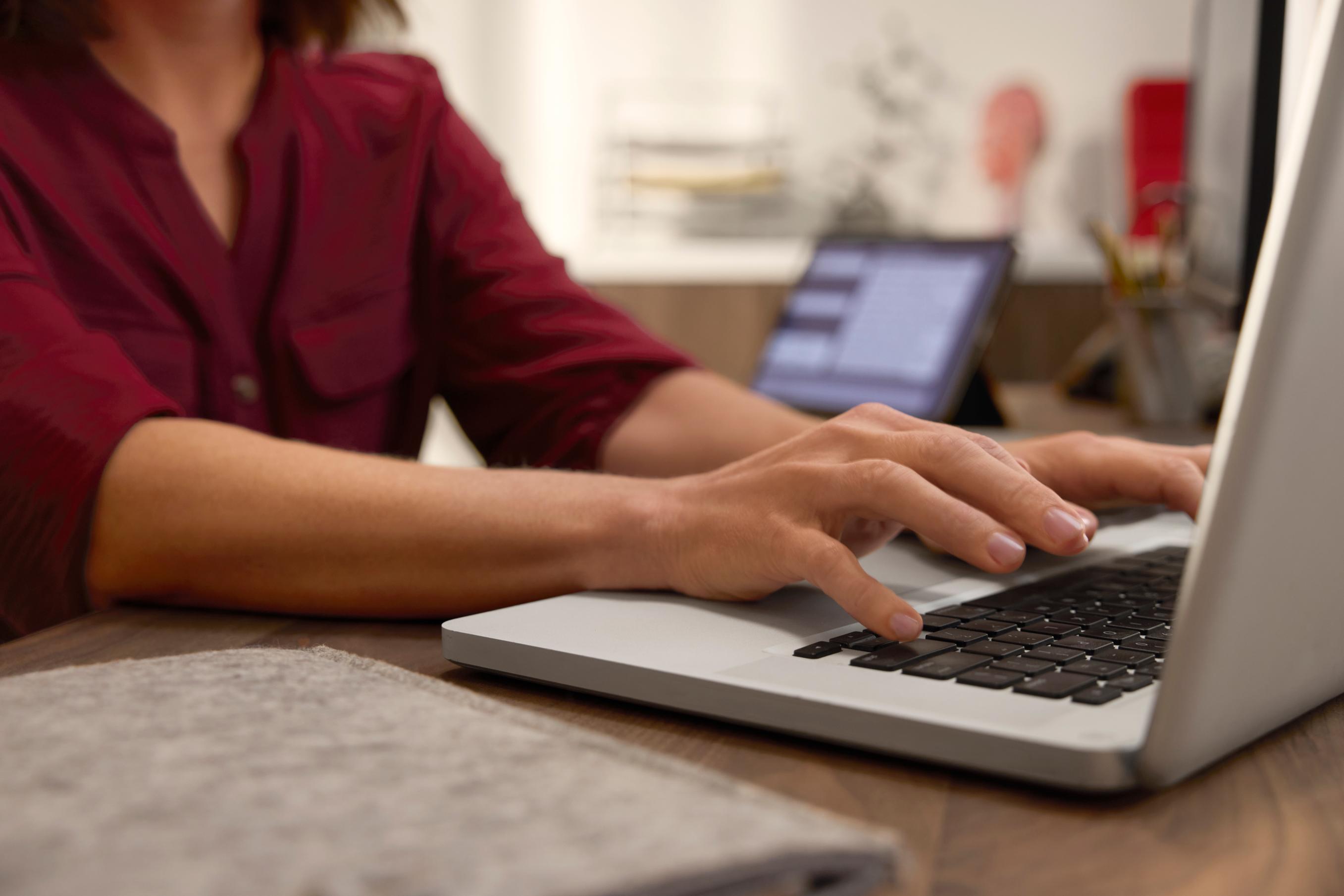 A woman typing on a laptop