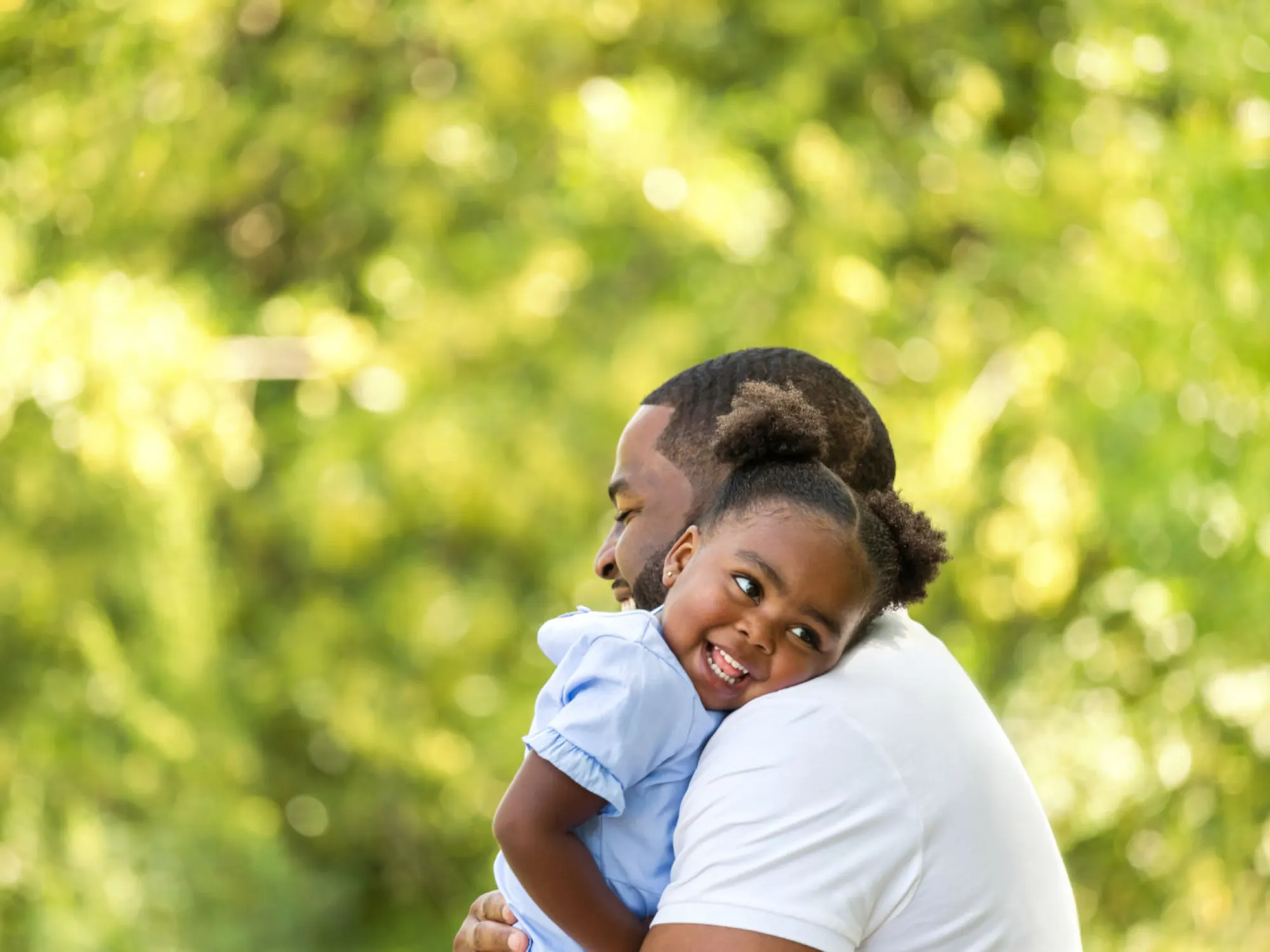 Black man hugging his young daughter