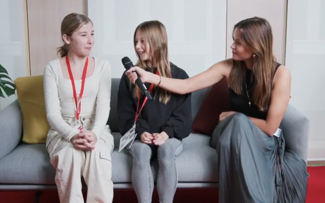 Three young people sitting on an office couch conducting an interview